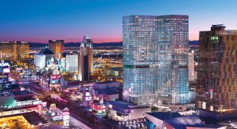 Waldorf Astoria Las Vegas - Las Vegas, NV. View of the Strip at dusk with illuminated hotels, casinos, and city lights against a clear evening sky.